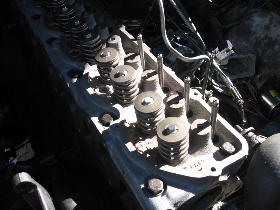 Close-up of an engine cylinder head showing valve springs and pushrods