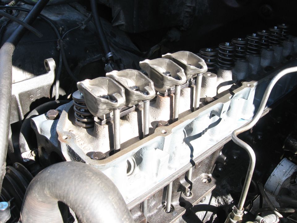 Close-up of engine valve train with rocker arms and springs visible