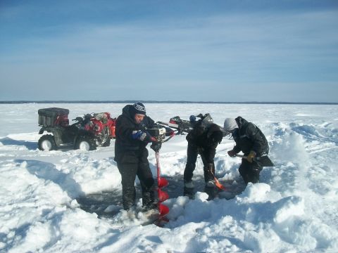 1986 Chevrolet Blazer - People ice fishing on a frozen body of water with ATVs nearby.