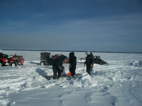 1986 Chevrolet Blazer - People and ATVs are gathered on a frozen lake, with some individuals appearing to be ice fishing.