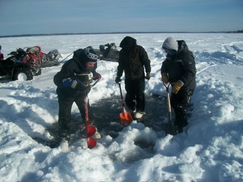 1986 Chevrolet Blazer - People are ice fishing on a frozen body of water with ATVs and sleds in the background.
