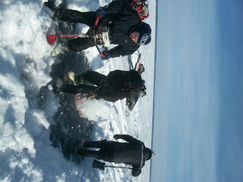 1986 Chevrolet Blazer - Three individuals are engaged in ice fishing activities on a frozen body of water, with a snowmobile nearby.