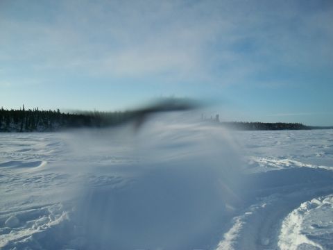 1986 Chevrolet Blazer - A vast snowy expanse under a clear blue sky, with a dark, hazy cloud obscuring the distant treeline.