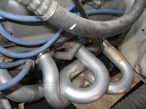 1994 Ford Bronco - Engine compartment detail showing custom exhaust headers with visible branding.