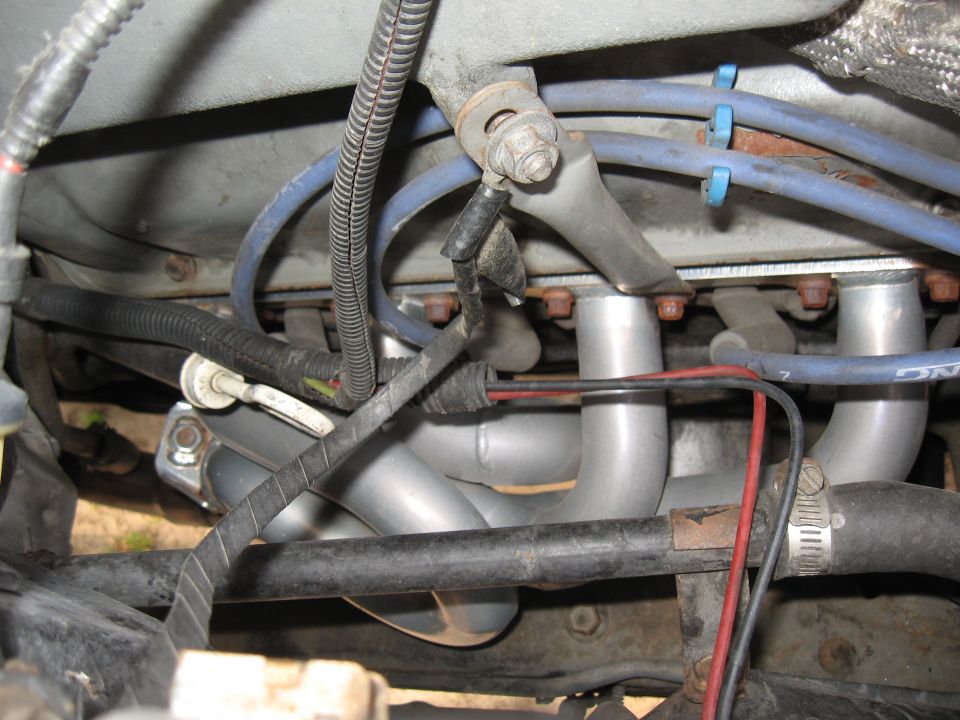 Engine exhaust headers with blue spark plug wires and black wiring