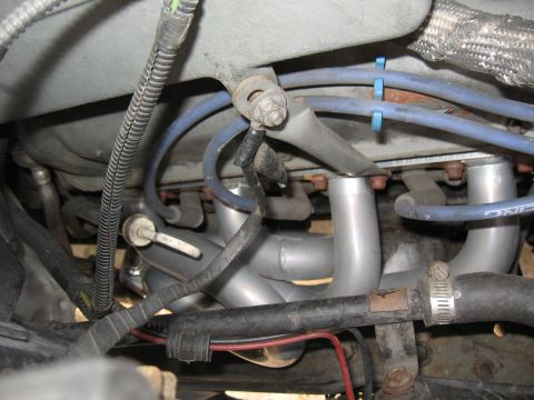 1994 Ford Bronco - Close-up of engine bay showing aftermarket exhaust headers and associated wiring and hoses.