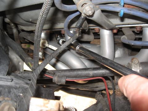 1994 Ford Bronco - Close-up view of engine bay components, focusing on exhaust headers and a tool.