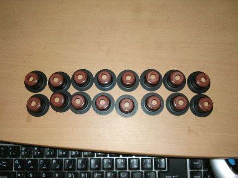 1998 Ford Crown Victoria - A collection of valve seals is laid out on a wooden surface, with a keyboard visible at the bottom.