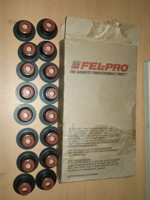 1998 Ford Crown Victoria - A box of Fel-Pro valve seals and loose valve seals are displayed on a wooden surface.