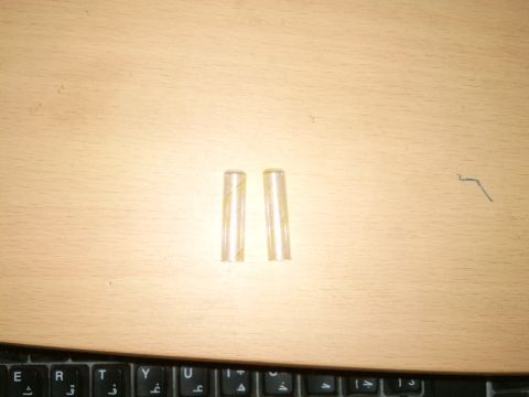 1998 Ford Crown Victoria - Two clear plastic tubes are visible on a wooden desk, with a keyboard in the foreground.