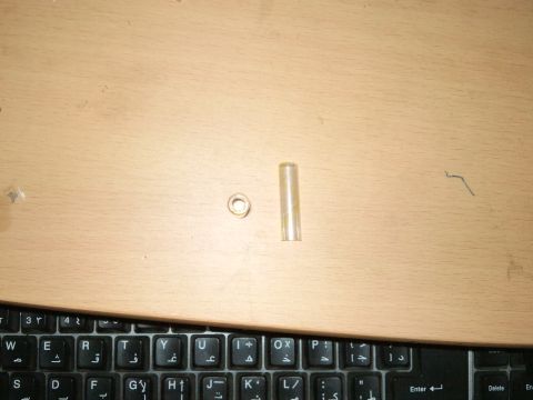 1998 Ford Crown Victoria - A close-up view of two automotive parts, a ring and a tube, on a desk surface.