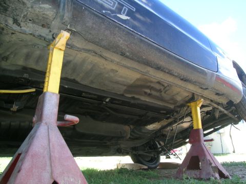 1995 Ford Probe - Car's undercarriage is visible while it's raised on jack stands.