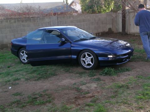 1995 Ford Probe - A blue 1995 Ford Probe is parked on a grassy area with the driver's side door ajar.