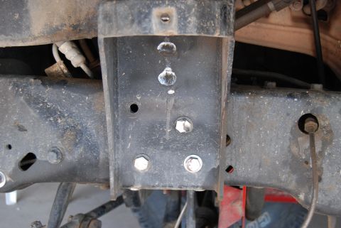 1982 Ford Bronco - This image shows a close-up view of the vehicle's frame and suspension system, with visible bolts and metal brackets.