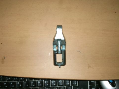 1998 Ford Crown Victoria - A valve spring compressor tool is shown on a desk, with a keyboard visible at the bottom.