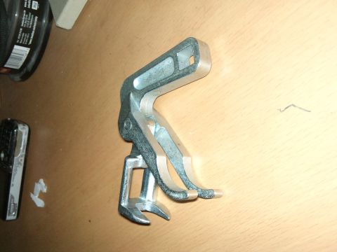 1998 Ford Crown Victoria - A valve spring compressor tool is shown on a table, with some text visible on an object to the left.