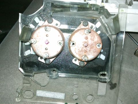 1998 Ford Crown Victoria - Close-up view of two instrument cluster gauges, showing signs of rust and the surrounding clear plastic assembly.