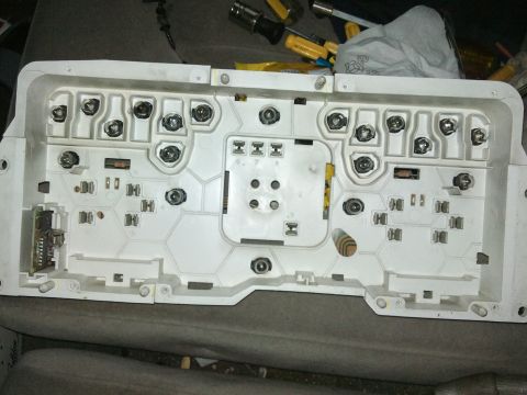 1998 Ford Crown Victoria - The rear of a vehicle's instrument cluster housing is shown, with various sockets for bulbs and electrical connections visible.