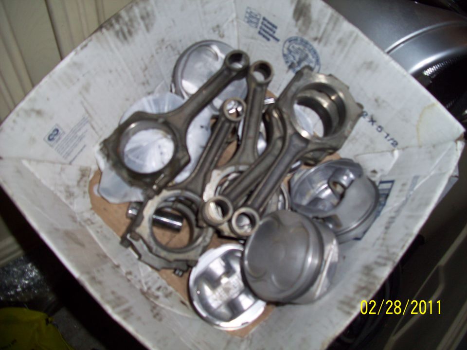 Engine pistons and connecting rods in a cardboard box