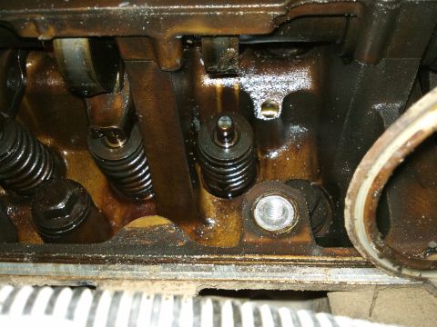 1998 Ford Crown Victoria - Close-up view of an engine's internal components, showing valve springs and rocker arms coated in oil.
