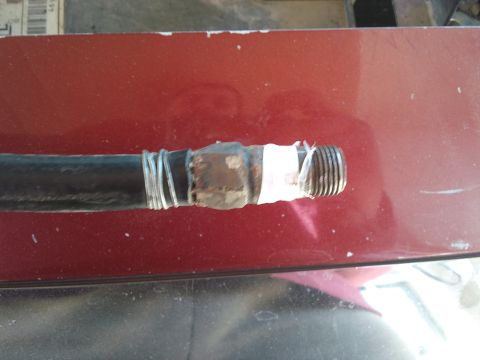1998 Ford Crown Victoria - A hose with a makeshift repair using wire and tape is shown.