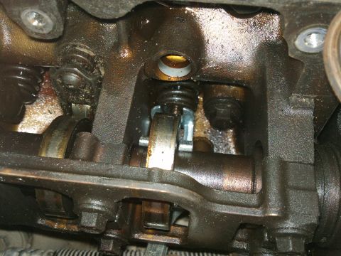 1998 Ford Crown Victoria - Internal view of an engine's valve train components, showing wear and oil. The Supermotors.net logo is present in the lower right corner.
