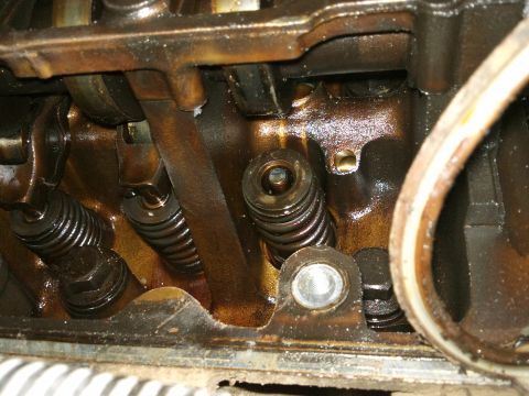 1998 Ford Crown Victoria - This image shows the internal components of an engine, specifically the valve train, with visible oil residue.