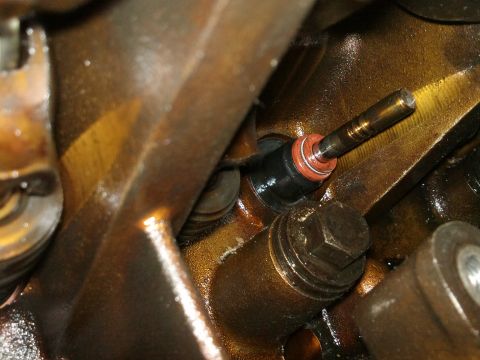 1998 Ford Crown Victoria - A close-up view of an engine's valve stem seal, showing its components and surrounding metal parts.
