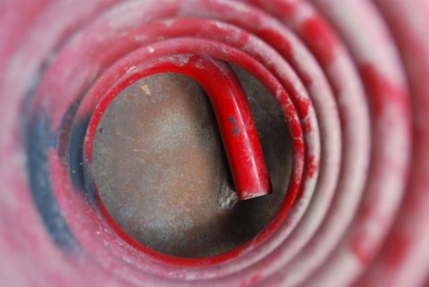 1982 Ford Bronco - Close-up view of a red coil spring, likely a suspension component.