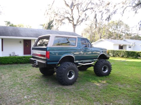 1978 Ford Bronco - This lifted SUV, possibly a Ford Bronco, is shown in a rear three-quarter view on a grassy lawn.