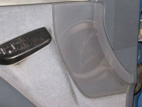 1993 Ford F-250 - Close-up of a vehicle's interior door panel, showing the power window and lock controls and a speaker grille.
