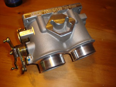 1989 Ford Bronco - Close-up of a BBK Power Plus Twin 61mm throttle body on a wooden surface.