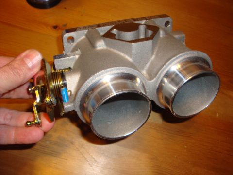 1989 Ford Bronco - A person's hand is shown operating the linkage on a dual throttle body part.