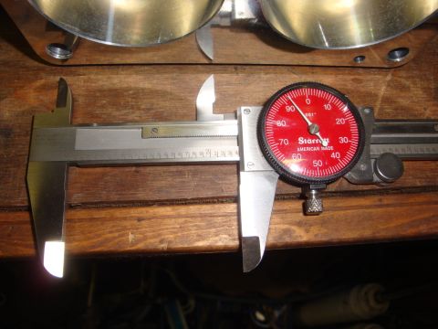 1989 Ford Bronco - A Starrett dial caliper is used to measure a metal component, likely for an engine rebuild.