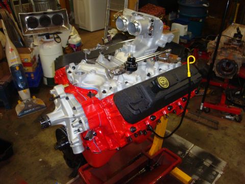 1989 Ford Bronco - A freshly rebuilt V8 engine sits on an engine stand in a garage setting.
