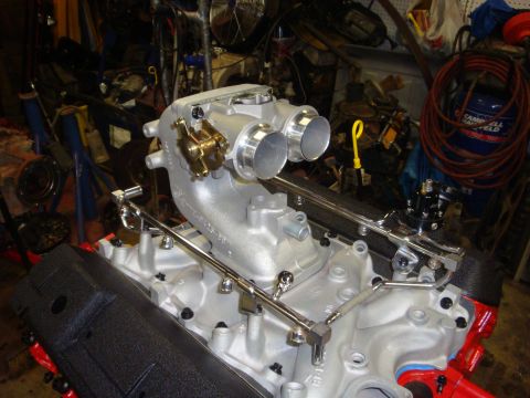 1989 Ford Bronco - Aftermarket intake manifold and fuel rails installed on an engine block in a workshop setting.