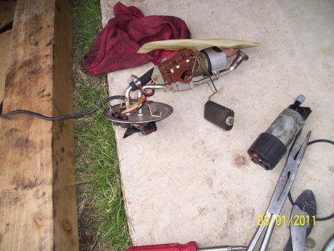 1995 Ford Probe - Fuel pump assembly and fuel pump removed from a vehicle, laid out with tools.