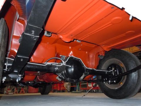 1972 Chevrolet Camaro - The undercarriage of a vehicle is shown, the rear axle and suspension components with an orange painted floor pan.