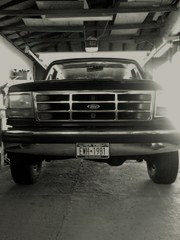 1993 Ford Bronco - Frontal view of a Ford truck parked indoors, showing its grille and headlights. The license plate is visible.