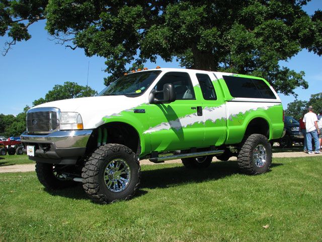 Lifted pickup truck, white and green paint, chrome wheels, 3/4 front view