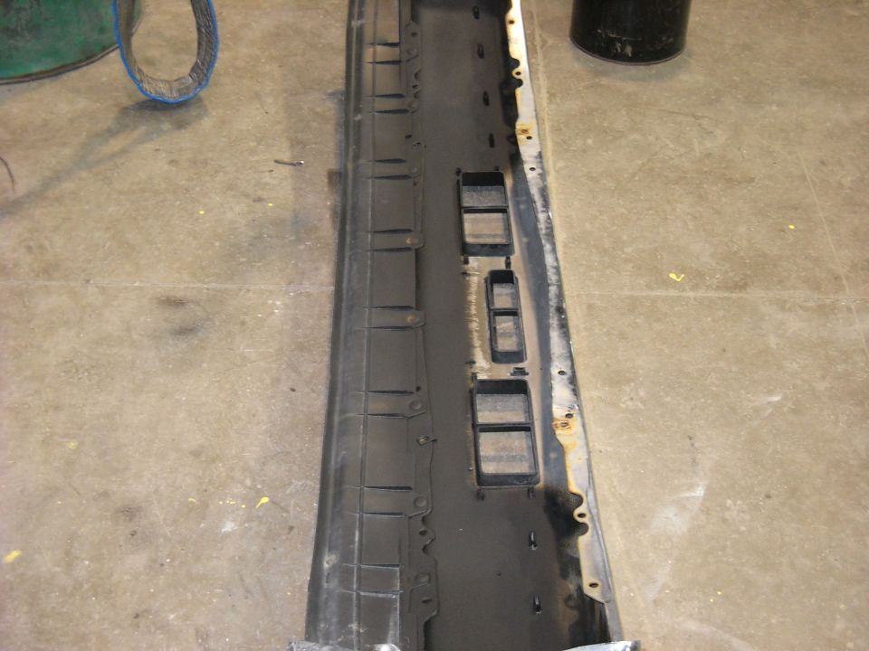 Black plastic and metal front bumper section with rectangular cutouts