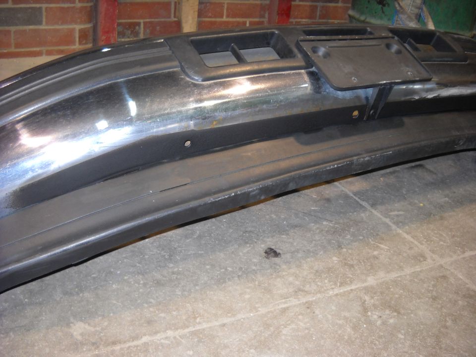 Black front bumper with chrome trim and a license plate bracket