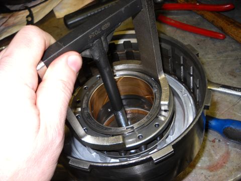 1993 Ford C-150 (Centurion Conversions) - A specialized tool is used to compress components within a transmission part during a rebuild process.