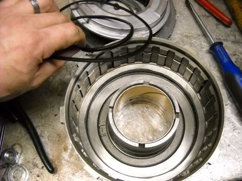 1993 Ford C-150 (Centurion Conversions) - Mechanic installs O-rings into a transmission clutch pack during an E4OD rebuild. Part number 1-8 is visible on the component.