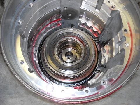 1993 Ford C-150 (Centurion Conversions) - Internal components of an automatic transmission, including clutch packs and gears, are visible with red fluid.
