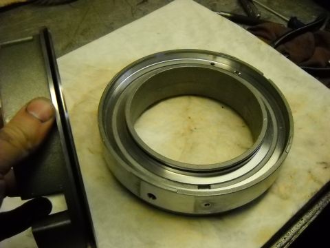1993 Ford C-150 (Centurion Conversions) - Metal transmission component being held and examined on a workbench.
