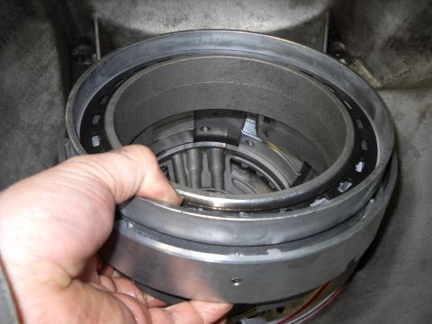1993 Ford C-150 (Centurion Conversions) - Close-up of a disassembled transmission part being held by a hand.