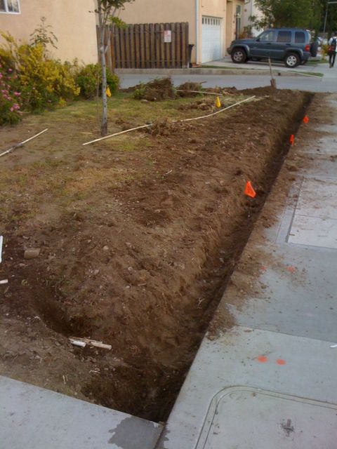 1968 Ford Mustang - A trench has been dug along the sidewalk in a residential area, with a dark SUV visible in the background.
