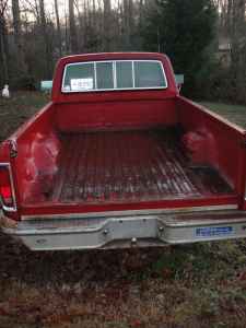 1995 Ford Bronco - Rear view of a red pickup truck bed with a chrome bumper.