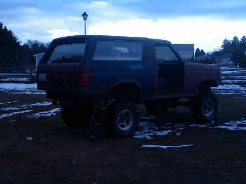 1988 Ford Bronco - This lifted 1987 Ford Bronco is shown in a three-quarter rear view with its doors open.